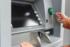 person putting debit / credit card into atm